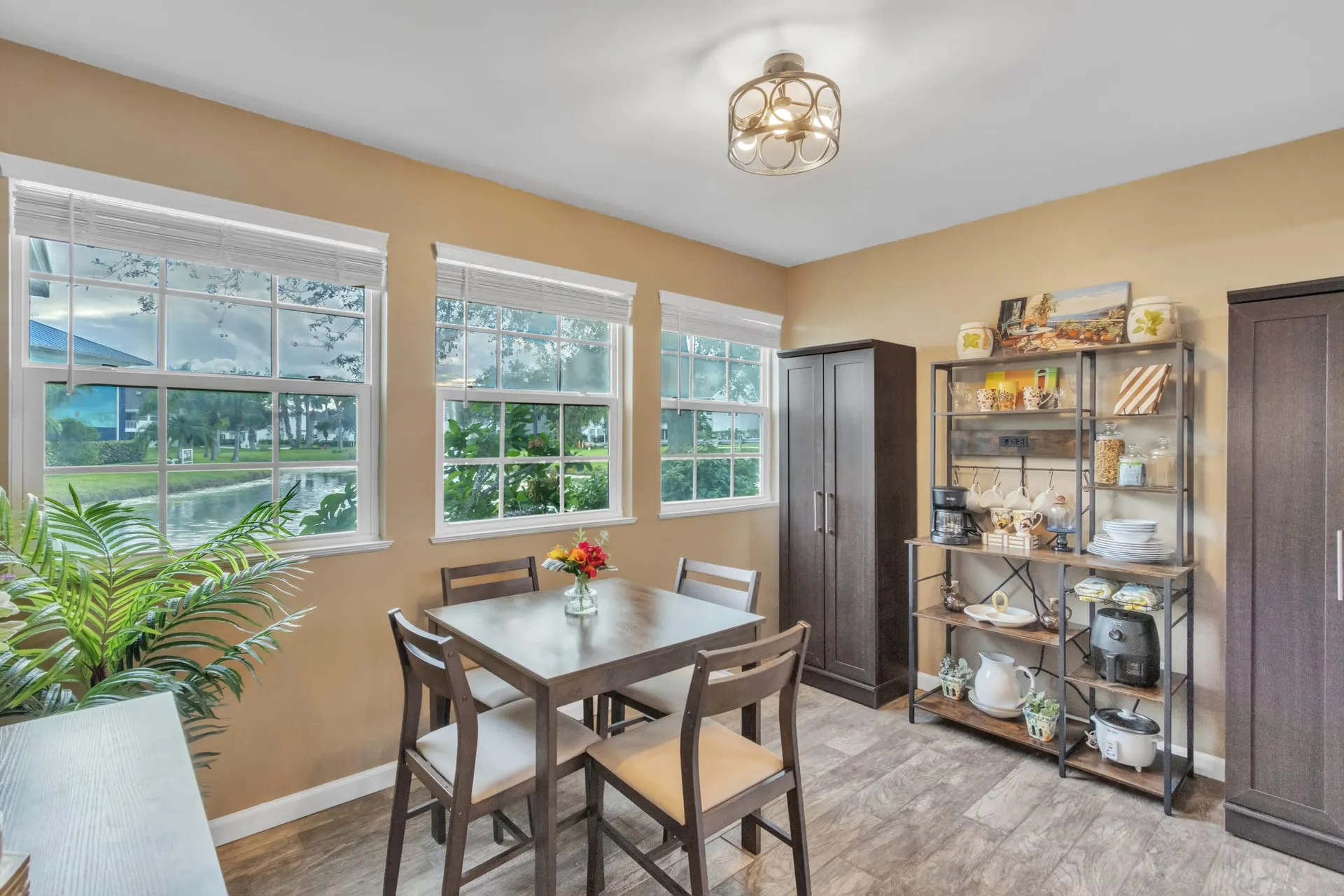 Breakfast nook with a table for four and large windows looking out to the lawn