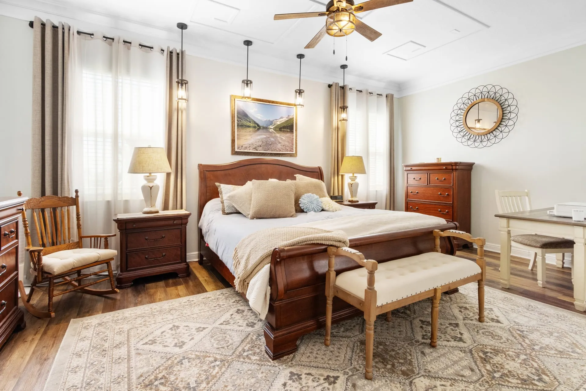 Primary bedroom with a sleigh bed, a ceiling fan and warm neutral decor