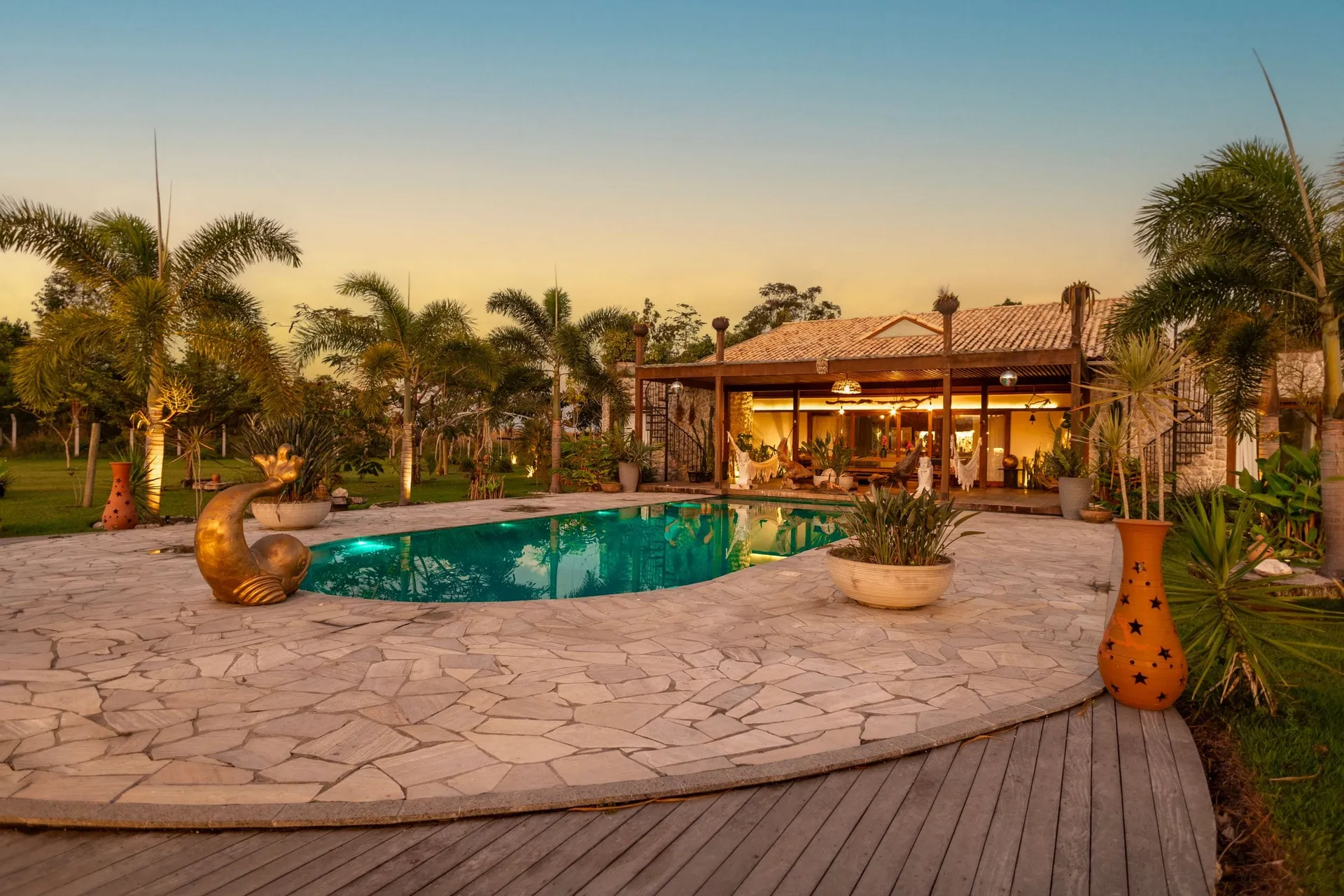 Airbnb photography of a vacation rental pool, palm trees and warmly lit villa at sunset in Central Florida
